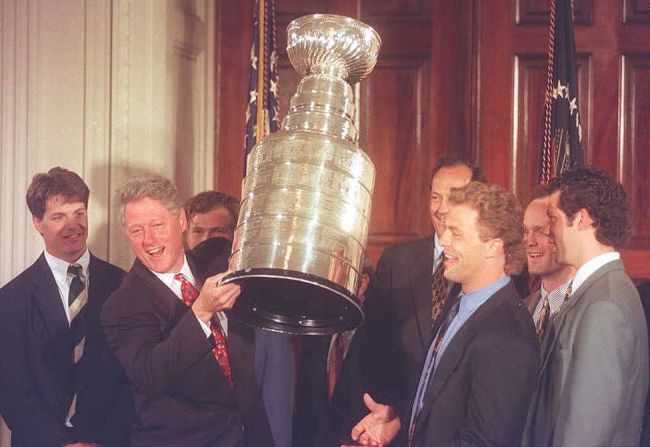 Clinton sostiene la Copa Stanley ganada por los campeones de la Liga Nacional de Hockey, los New Jersey Devils.