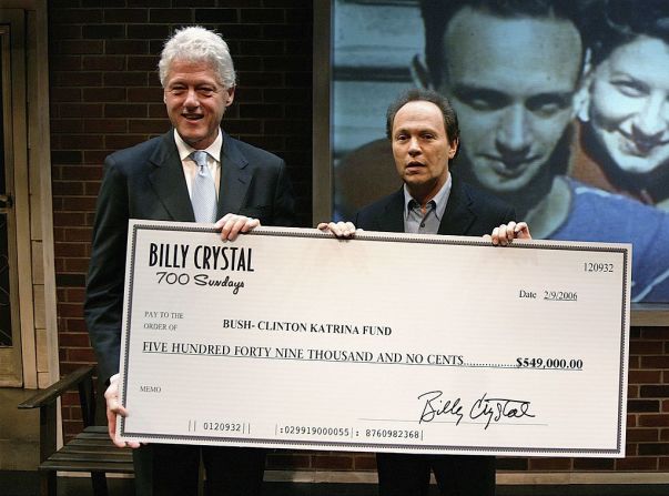 El expresidente Bill Clinton y el embajador de Estados Unidos en el esfuerzo de socorro del huracán Katrina aceptan un cheque del actor Billy Crystal por el esfuerzo realizado antes de la presentación del espectáculo individual del Sr. Crystal " 700 Sundays "en el Wilshire Theatre el 9 de febrero de 2006 en Beverly Hills, California.