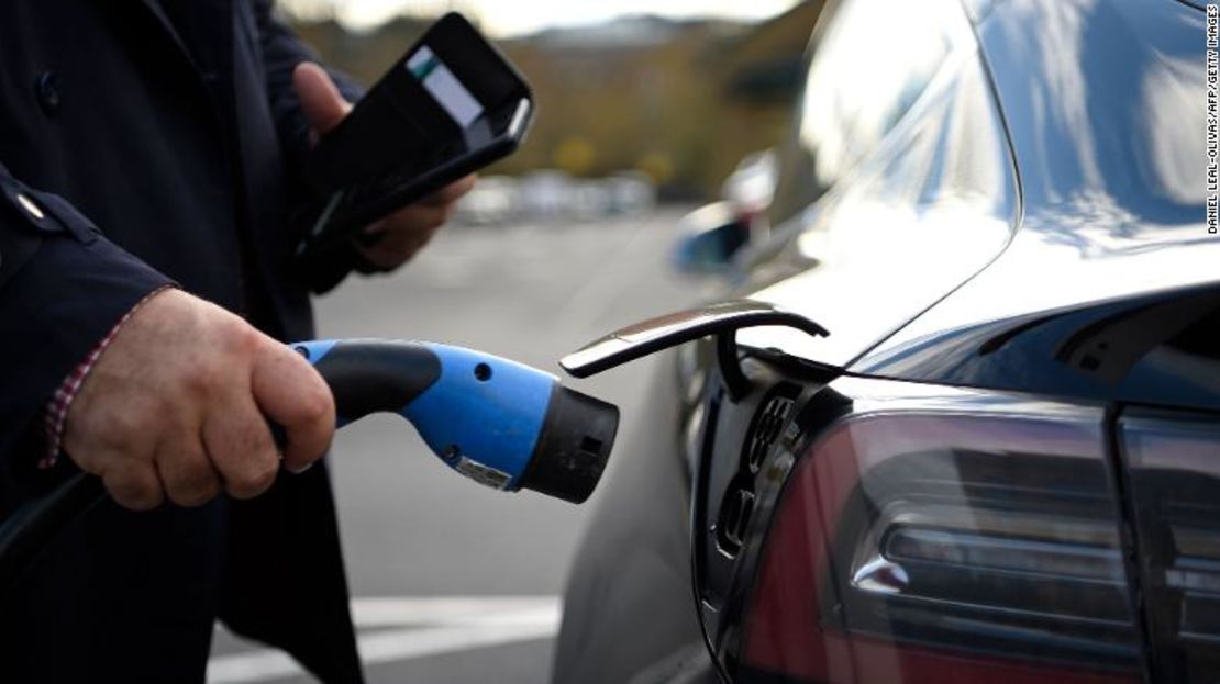 Un cliente se prepara para cargar un auto eléctrico Tesla en un supermercado del norte de Londres.