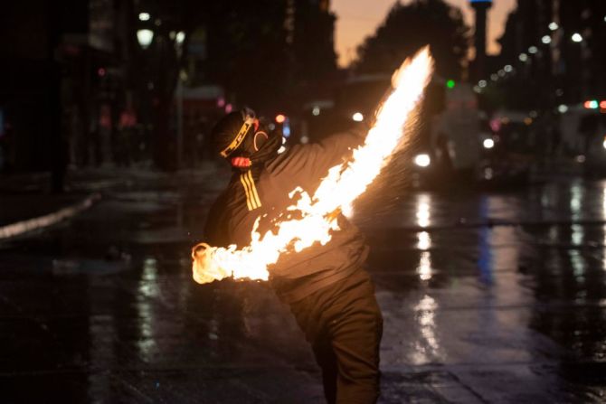 Un manifestante lanza un cóctel molotov durante los enfrentamientos con la policía antidisturbios cerca del Palacio Presidencial de La Moneda.