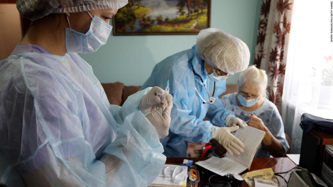 Trabajadores médicos vacunan a un paciente en su casa.