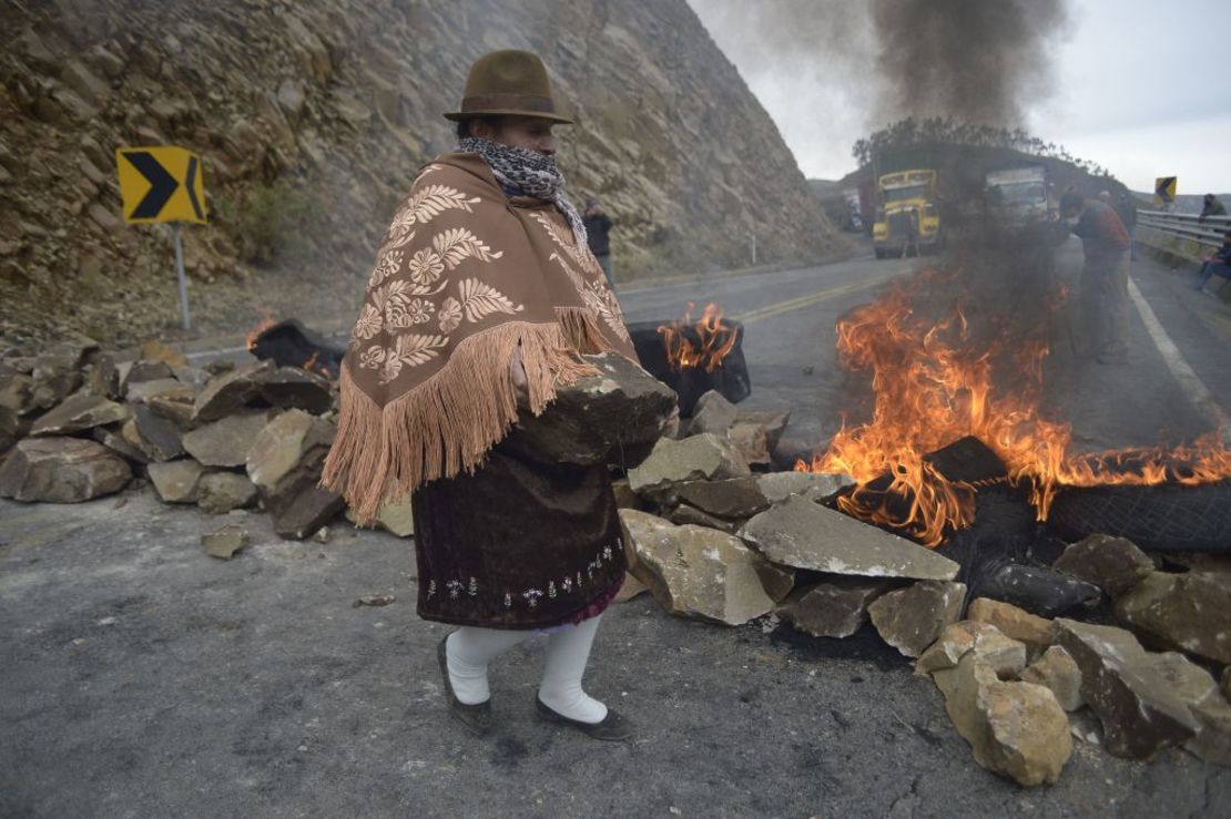 Una mujer indígena bloquea una carretera que une la costa y la sierra, cerca de Zumbahua, en Ecuador, el 26 de octubre de 2021, antes de una protesta contra las políticas económicas del gobierno.