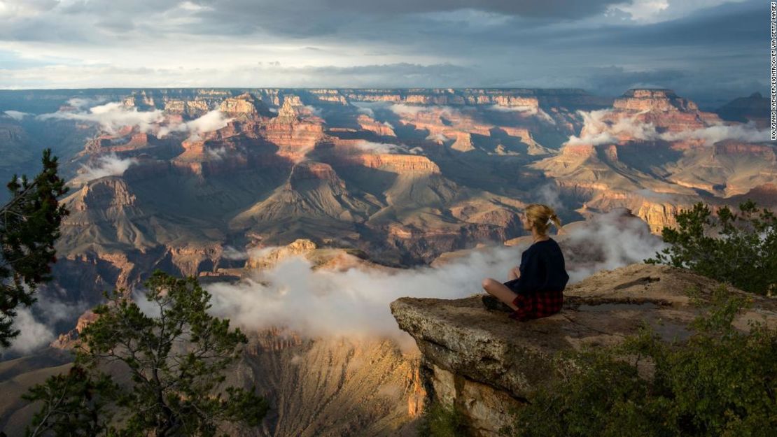 Una mujer se sienta cerca de Yavapai Point, en el acantilado South Rim, con vistas al Gran Cañón, uno de los tres sitios del Patrimonio Mundial de Estados Unidos que, según la Unesco, se ha convertido en una fuente de emisiones de carbono.