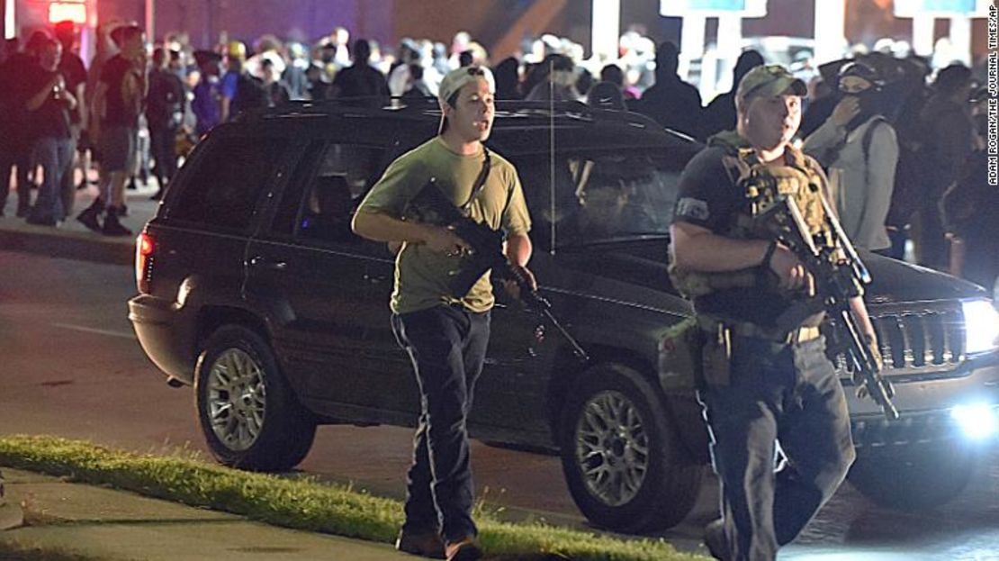 Kyle Rittenhouse, a la izquierda con una gorra al revés, camina por Sheridan Road en Kenosha, Wisconsin, alrededor de las 11 de la noche del martes 25 de agosto de 2020, junto a otro civil armado.