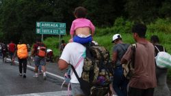 TOPSHOT - Central American and Haitian migrants are seen heading in a caravan to the US, in Huixtla, Chiapas State, Mexico, on September 4, 2021. - A caravan of some 300 mainly Central American people, some carrying children and suitcases, set out from Tapachula on foot Saturday hoping to reach the United States, the fourth such procession in a week. (Photo by JACKY MUNIELLO / AFP)