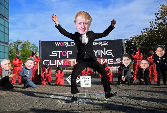 Activistas con máscaras que representan a algunos líderes mundiales, entre ellos el primer ministro Boris Johnson, participan en una manifestación con el tema del "Juego del Calamar" cerca del Scottish Event Campus, sede de la COP26 en Glasgow, el 2 de noviembre de 2021.