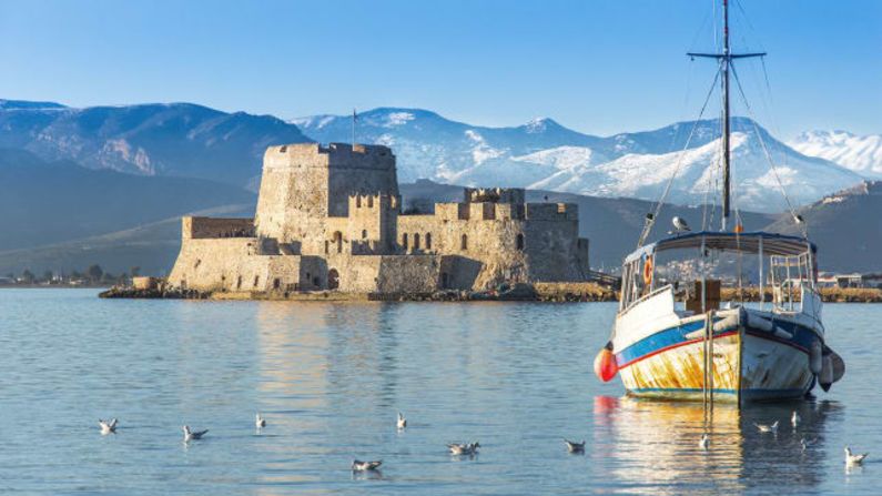 Nafplio, la primera capital de la Grecia moderna, se extiende a ambos lados del mar Egeo en el Peloponeso, con su castillo de construcción veneciana hundiéndose en el agua.