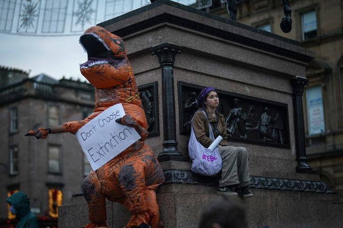 "No elijan la extinción" es el mensaje de este dinosaurio que participa en las manifestaciones en Glasgow el 5 de noviembre de 2021.