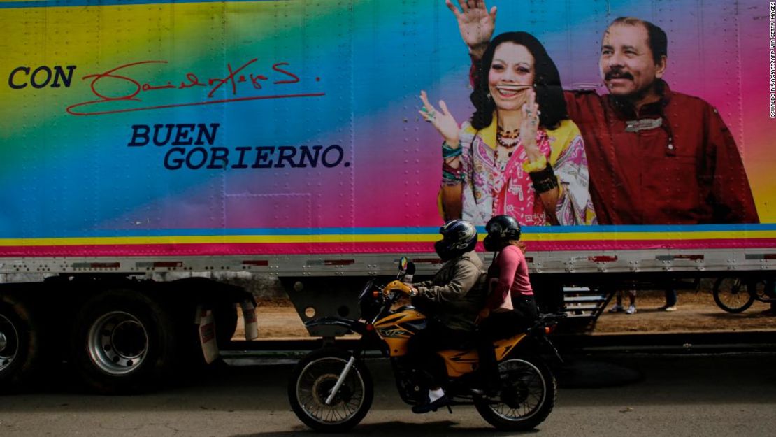 Una motocicleta pasa junto a una pancarta del presidente de Nicaragua, Daniel Ortega, y su esposa y compañera de fórmula, Rosario Murillo, colocada en una clínica móvil en Masaya el 2 de noviembre de 2021.