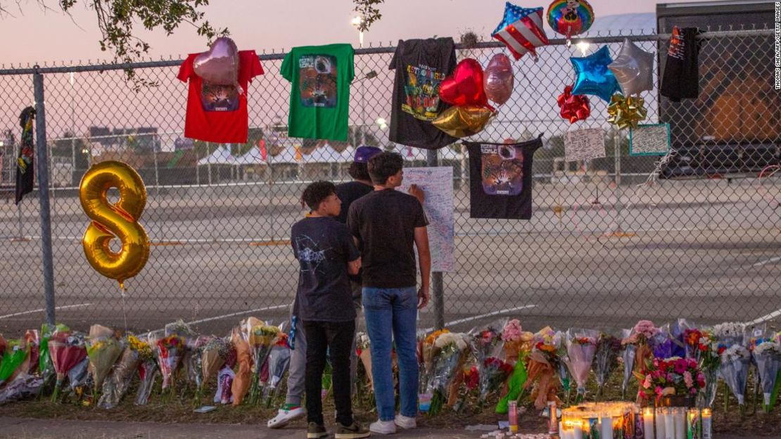 Los asistentes al concierto Isaac Hernández y Matthias Coronel ven a Jesús Martínez firmar una pizarra conmemorativa el domingo en NRG Park en Houston.