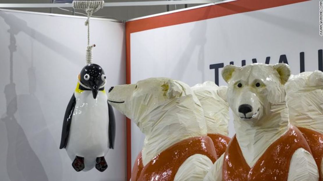 El stand de Tuvalu en la COP26 incluye una escultura del eco-artista Vincent Huang que muestra osos polares con chalecos salvavidas y un pingüino colgado de una soga.