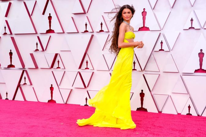 En otro tributo a una estrella importante, Zendaya asistió a los Oscar 2021 con un vestido amarillo que dejaba al descubierto el abdomen inspirado en uno de los atuendos de Cher. Chris Pizzello / Pool / Getty Images