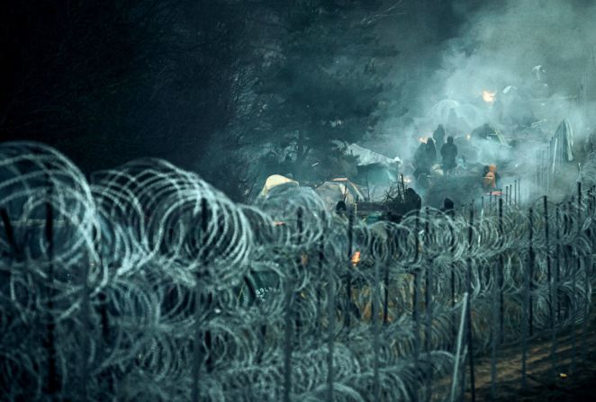 En esta imagen publicada por el Ministerio de Defensa Nacional de Polonia, los migrantes son vistos detrás de un alambre de púas en la frontera con Belarús.