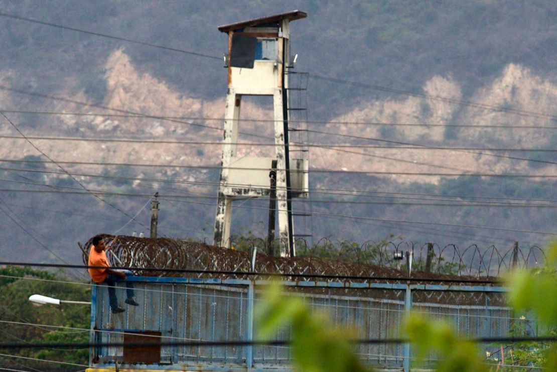 Un recluso se sienta en una cerca en la Penitenciaría Litoral, en Guayaquil, luego de los enfrentamientos del 2 de noviembre de 2021. Crédito: FERNANDO MENDEZ / AFP vía Getty Images