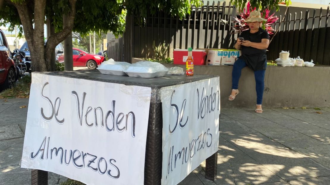 Tras ser despedida Milagro Cabrera vende platos de comida en una calle de San Salvador para generar ingresos y mantener a sus dos hijos, de 12 y 15 años.
