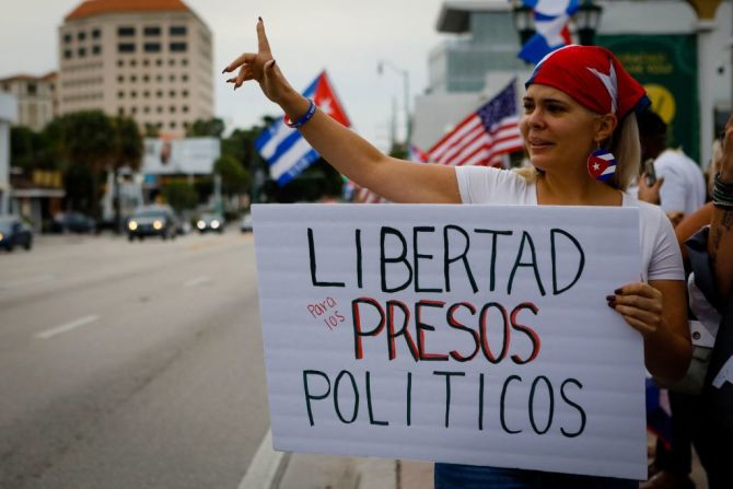 Una mujer sostiene un letrero que pide la liberación de los presos políticos en Cuba.