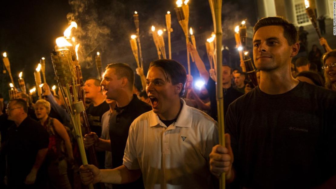 Los supremacistas blancos cantan contra los manifestantes después de marchar por el campus de la Universidad de Virginia con antorchas en Charlottesville, Virginia, el 11 de agosto de 2017.