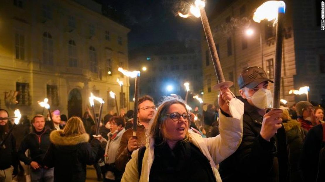 Manifestantes opuestos al confinamiento sostienen antorchas en Viena, Austria, el sábado.