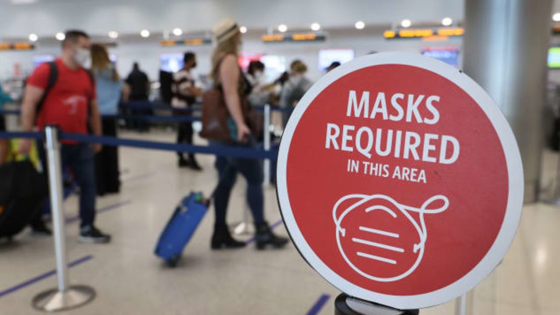 Un cartel sobre el requisito federal de uso de mascarilla se ve mientras los viajeros se preparan para registrarse en el Aeropuerto Internacional de Miami el 1 de febrero de 2021, el día en que la nueva norma entró en vigor.