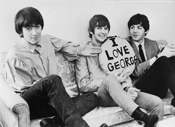 Alrededor de 1964: tres de los cuatro miembros de The Beatles sentados en un sofá. De izquierda a derecha: George Harrison, Ringo Starr y Paul McCartney. Starr sostiene una almohada con la leyenda "I LOVE GEORGE".