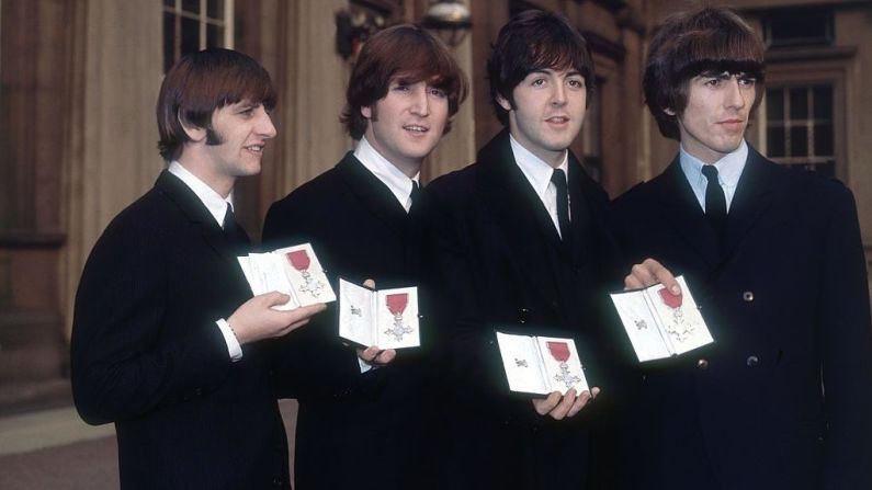 26 de octubre de 1965: The Beatles sostienen sus MBE tras una ceremonia de investidura en el Palacio de Buckingham en Londres.