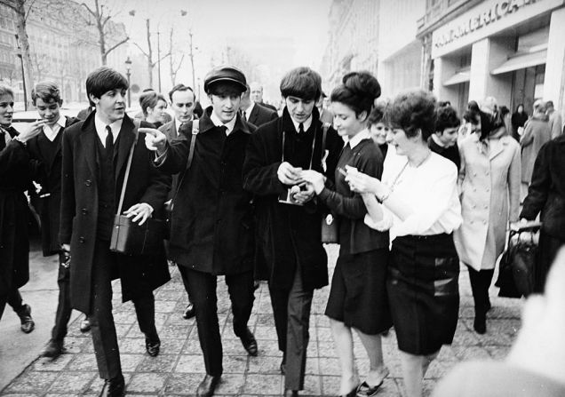 Los miembros de The Beatles George Harrison, Paul McCartney y John Lennon con sus fans, alrededor de 1968.