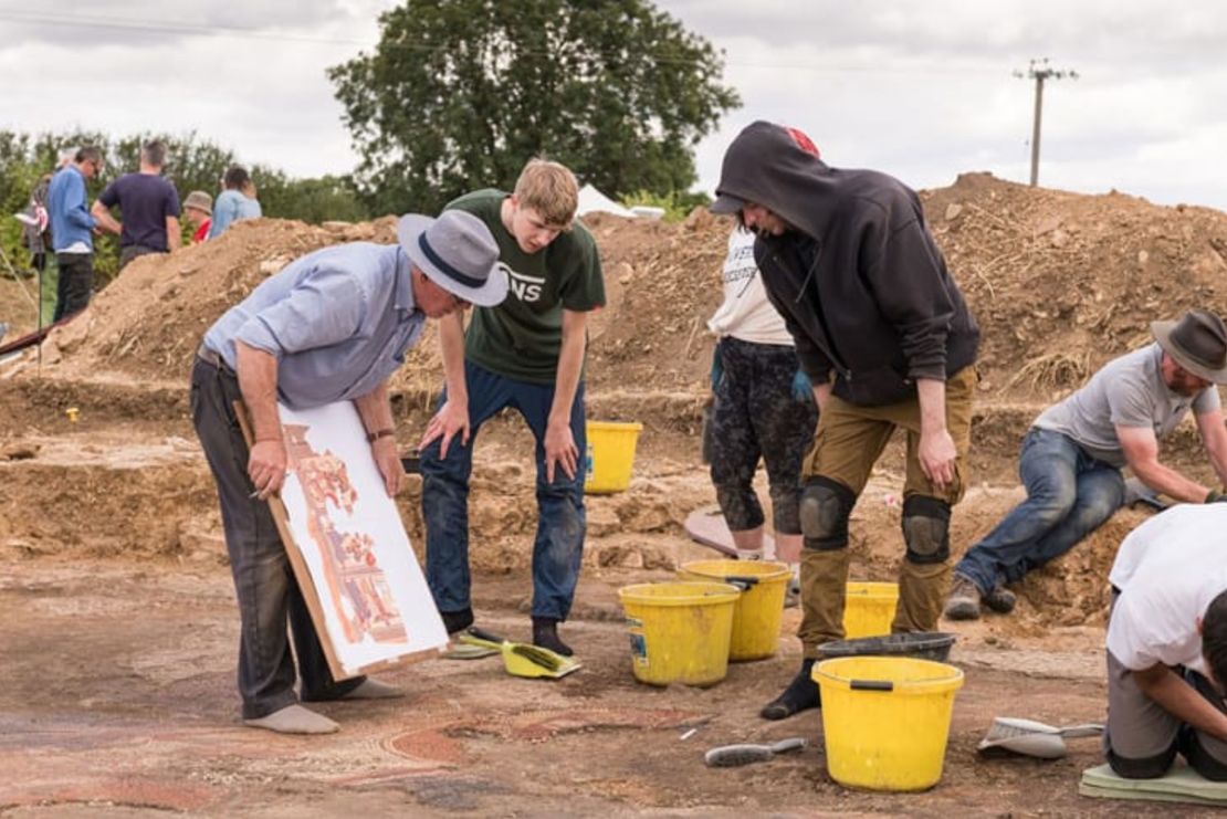 Los arqueólogos toman notas durante la excavación del mosaico. Crédito: Historic England Archive