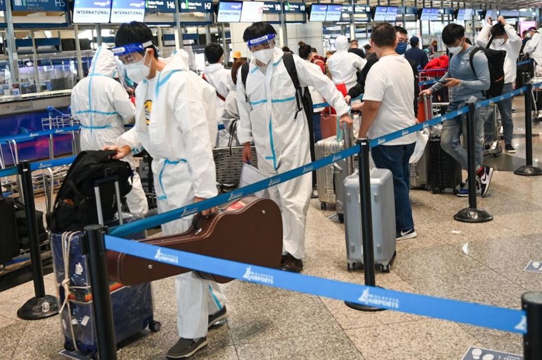 Pasajeros con equipo de protección personal hacen cola para registrarse para su vuelo en el Aeropuerto Internacional de Kuala Lumpur, en Sepan, el 29 de noviembre de 2021.