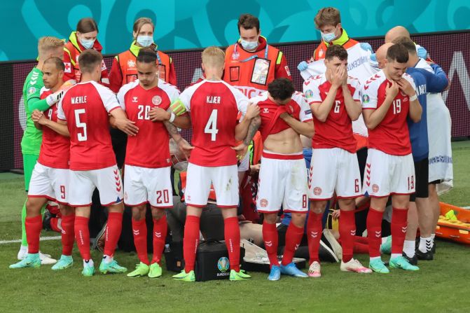 12 de junio — jugadores de fútbol de Dinamarca rodean con sus brazos a su compañero Christian Eriksen mientras los paramédicos trabajan para reanimarlo durante un partido de la Eurocopa 2020. Eriksen se desplomó en medio del partido y tuvo que ser reanimado con RCP y un desfibrilador.