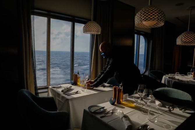 27 de junio — un trabajador pone la mesa en un restaurante del crucero Celebrity Edge, el primer crucero con ingresos que parte de Estados Unidos desde el inicio de la pausa inducida por la pandemia. El barco partió de la costa de Florida para viajar a la Costa Maya, en México.