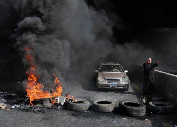 8 de marzo — un sacerdote suplica a los manifestantes antigubernamentales en Zouk Mosbeh (Líbano) que le dejen pasar con su vehículo. La barricada improvisada fue instalada por los manifestantes, frustrados por las pésimas condiciones económicas del país.