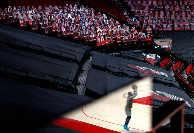 23 de marzo — Damian Lillard se refleja en un plexiglás mientras calienta para un partido de la NBA en Portland, Oregón.