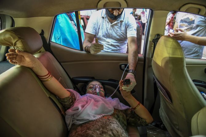 25 de abril — una paciente de covid-19 recibe oxígeno en un automóvil estacionado mientras espera que haya una cama de hospital disponible en Nueva Delhi.