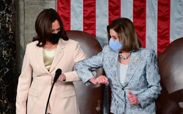 28 de abril — la vicepresidenta de EE.UU., Kamala Harris, a la izquierda, saluda a la presidenta de la Cámara de Representantes, Nancy Pelosi, con un codazo antes del discurso del presidente Joe Biden ante el Congreso. Fue la primera vez en la historia que dos mujeres se sentaron detrás del presidente para un discurso conjunto.