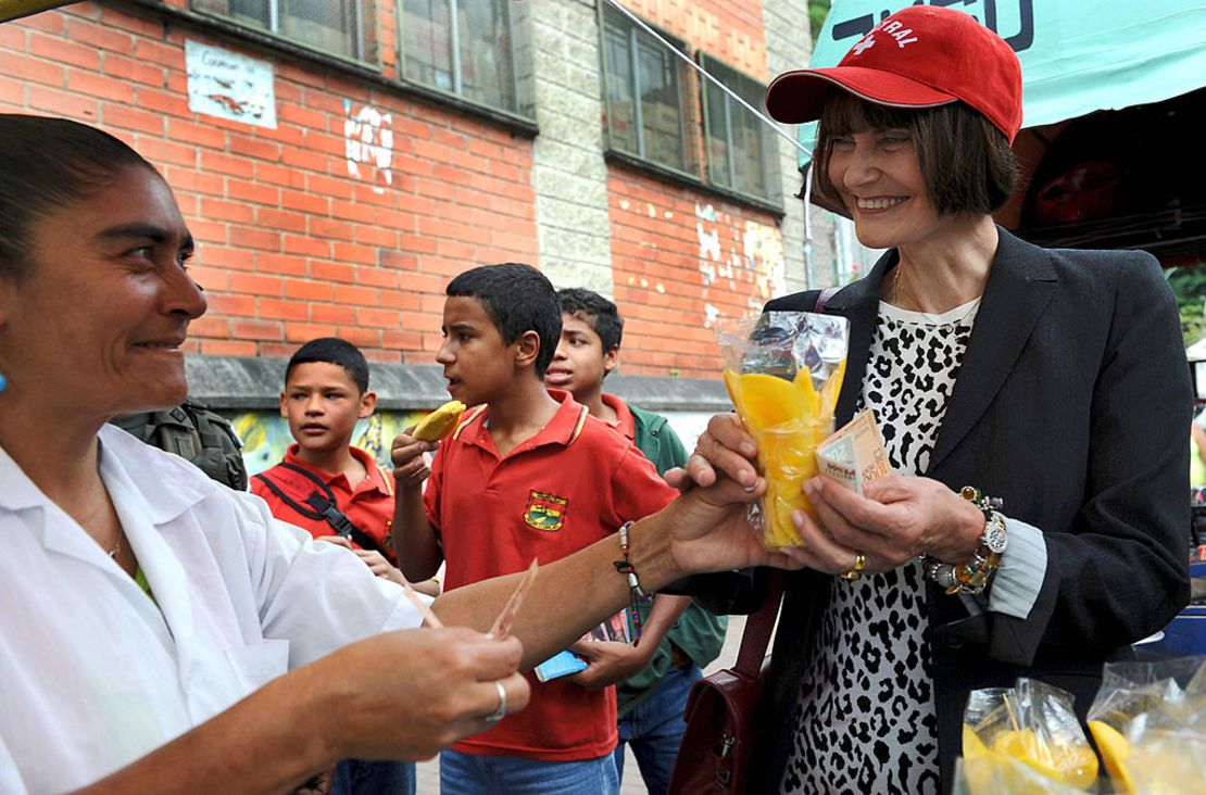 La ministra suiza de Relaciones Exteriores Micheline Calmy-Rey compra mango picado de una vendedora en Medellín, Colombia, en 2008.