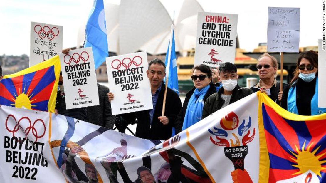 Manifestantes sostienen pancartas y carteles mientras asisten a una manifestación en Sydney el 23 de junio de 2021 para pedir al gobierno de Australia que boicotee los Juegos Olímpicos de Invierno de Beijing 2022 por el historial de derechos humanos de China.