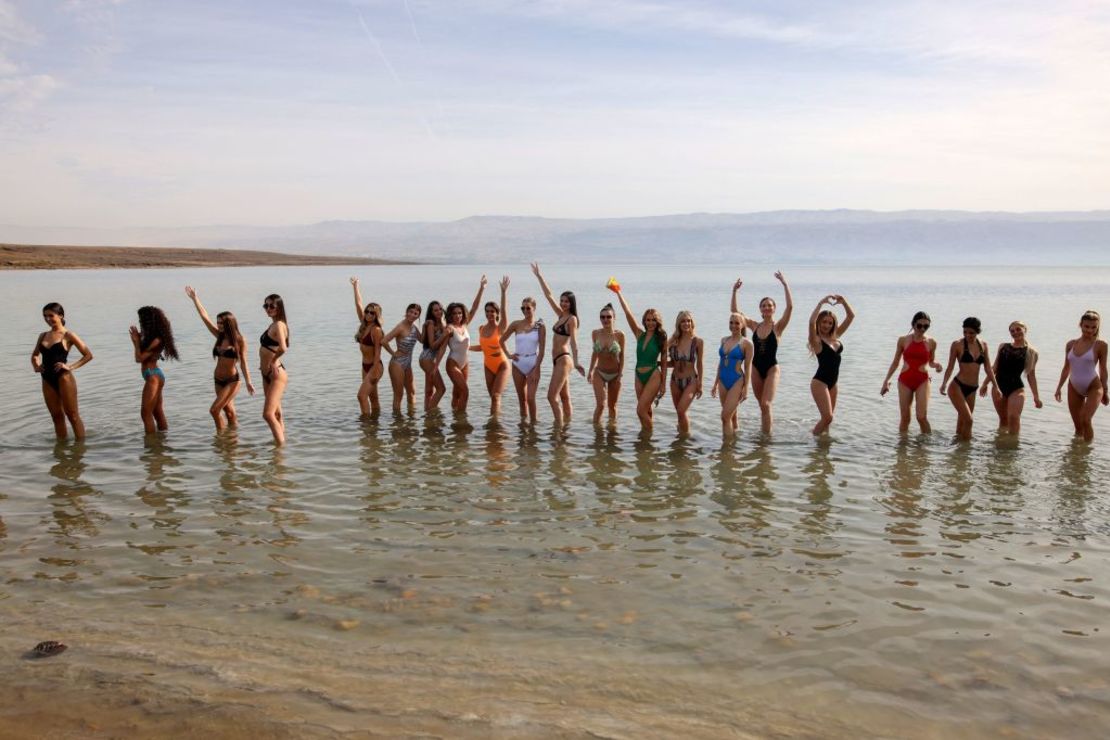 Aspirantes a Miss Universo posan para una foto en las aguas del Mar Muerto. Crédito: AHMAD GHARABLI / AFP a través de Getty Images