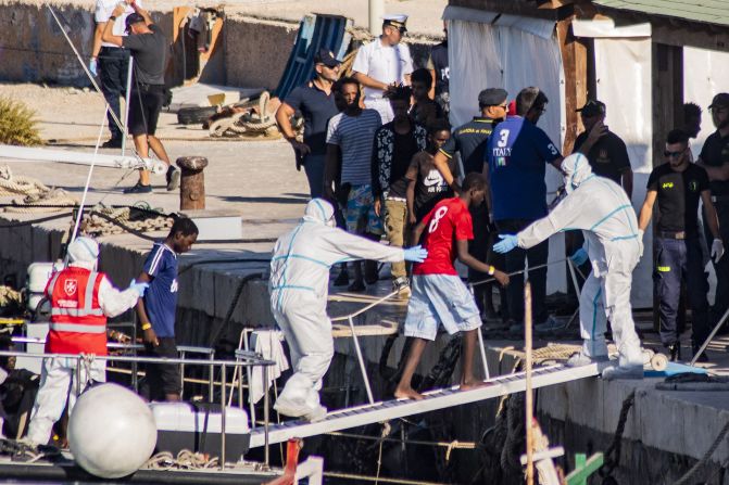 Migrantes a bordo del barco de la Guardia di Finanza llegan a la isla italiana de Lampedusa en agosto de 2019 tras ser evacuados del barco de rescate de la ONG española Open Arms, que estuvo veinte días en el mar a la espera de que Europa permitiera desembarcar a los migrantes en puerto seguro.