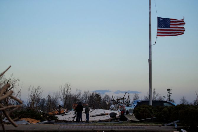 Las personas inspeccionan los daños causados por el tornado en el centro de la ciudad el 11 de diciembre de 2021 en Mayfield, Kentucky.