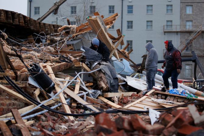 La gente busca en un edificio dañado por el tornado el 11 de diciembre de 2021 en Mayfield, Kentucky.