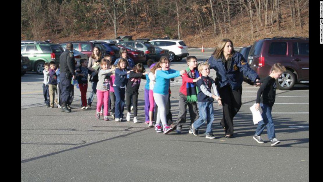 Agentes dirigen una fila de niños que salieron de la escuela tras el tiroteo.