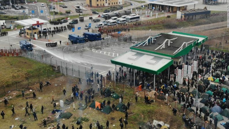 Agentes polacos utilizaron cañones de agua contra los migrantes reunidos en el puesto de control de Bruzgi-Kuznica, en la frontera entre Polonia y Belarús en noviembre de 2021. Los manifestantes dijeron que su enojo se debía a que habían estado varados en el frío extremo y sin servicios básicos en los campamentos.