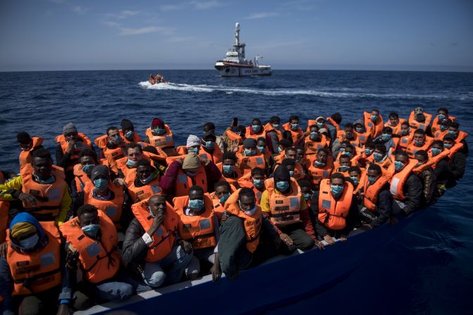 Migrantes de distintas nacionalidades aguardan en la embarcación de madera en la que viajaban para ser trasladados al barco de la ONG española Open Arms en marzo de 2021.