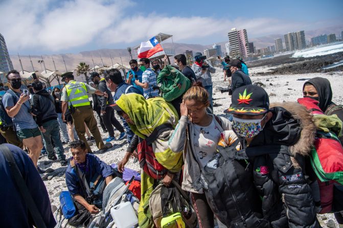 Migrantes venezolanos se refugian en la orilla del mar para evitar ser atacados por manifestantes durante una marcha de protesta contra la migración ilegal en Iquique, Chile, en septiembre de 2021.