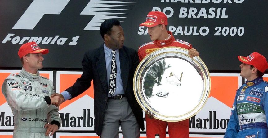 26 de marzo de 2000: Pelé asiste al Gran Premio de Brasil y saluda en el podio a David Coulthard, Michael Schumacher y Giancarlo Fisichella. Crédito: VANDERLEI ALMEIDA / AFP a través de Getty Images