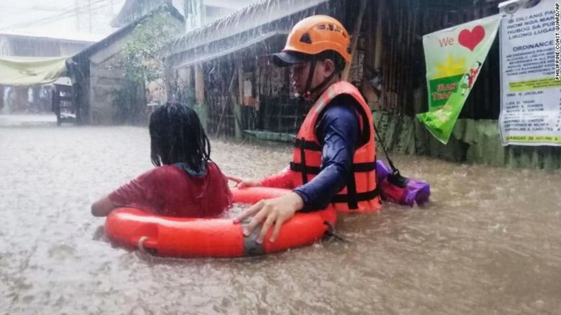 Un rescatista ayuda a una niña a atravesar las inundaciones causadas por el tifón Rai en la ciudad de Cagayán de Oro, Filipinas, el 16 de diciembre.