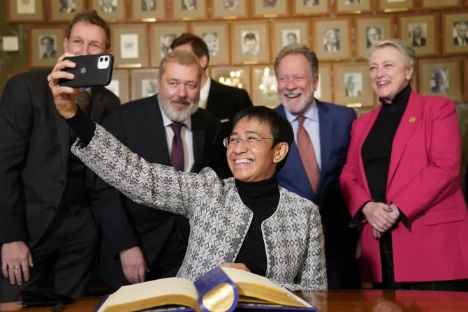 9 de diciembre – la periodista filipina estadounidense Maria Ressa, que ganó el Premio Nobel de la Paz este año junto con el editor del periódico ruso Dmitry Muratov, se toma una selfie con Muratov, el segundo desde la izquierda, y del Comité Nobel noruego durante una conferencia de prensa en Oslo, Noruega.