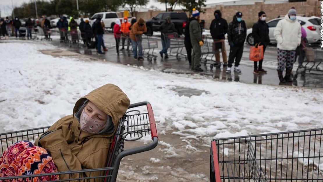 Camilla Swindle, de 19 años, se sienta en un carrito de compras mientras ella y su novio esperan en una larga fila para abastecerse en una tienda de comestibles en Austin, Texas, el 16 de febrero de 2021.