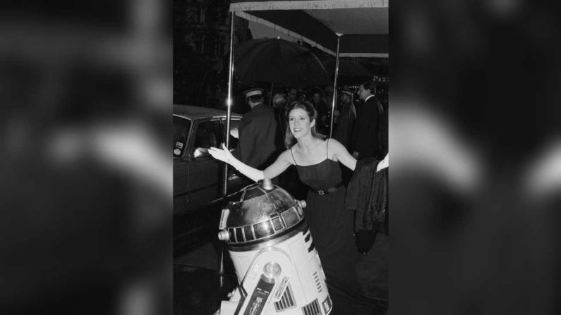 Carrie Fisher y el personaje de ficción R2-D2 a su llegada al estreno de 'El Imperio Contraataca', en el Odeon Leicester Square, Londres, Reino Unido, el 20 de mayo de 1980.