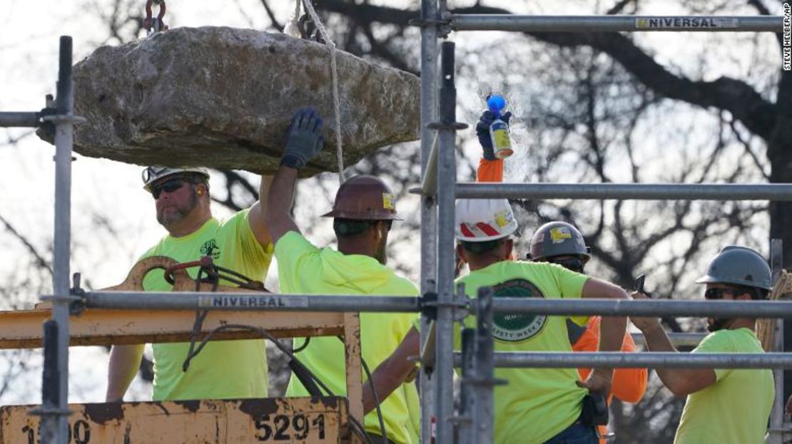 Los trabajadores guían una piedra que contiene una cápsula del tiempo colocada en 1887.